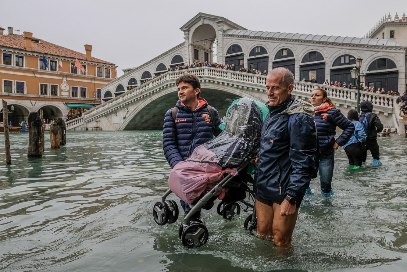 Tourists negotiate flooded Venice – where the water has hit decade-high levels after recent storms.