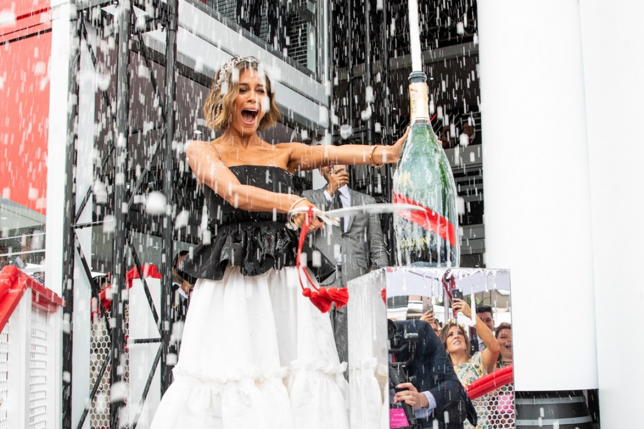 Nathalie Kelley gets the right kind of downpour at the Mumm Marquee at the 2018 Melbourne Cup. 