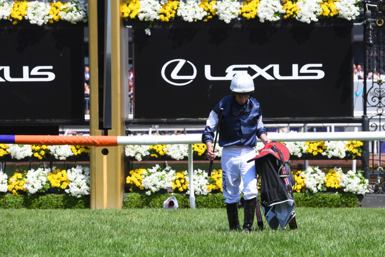 Jockey Ryan Moore walks back to the mounting yard after The Cliffsofmoher broke down in the Melbourne Cup at Flemington. 