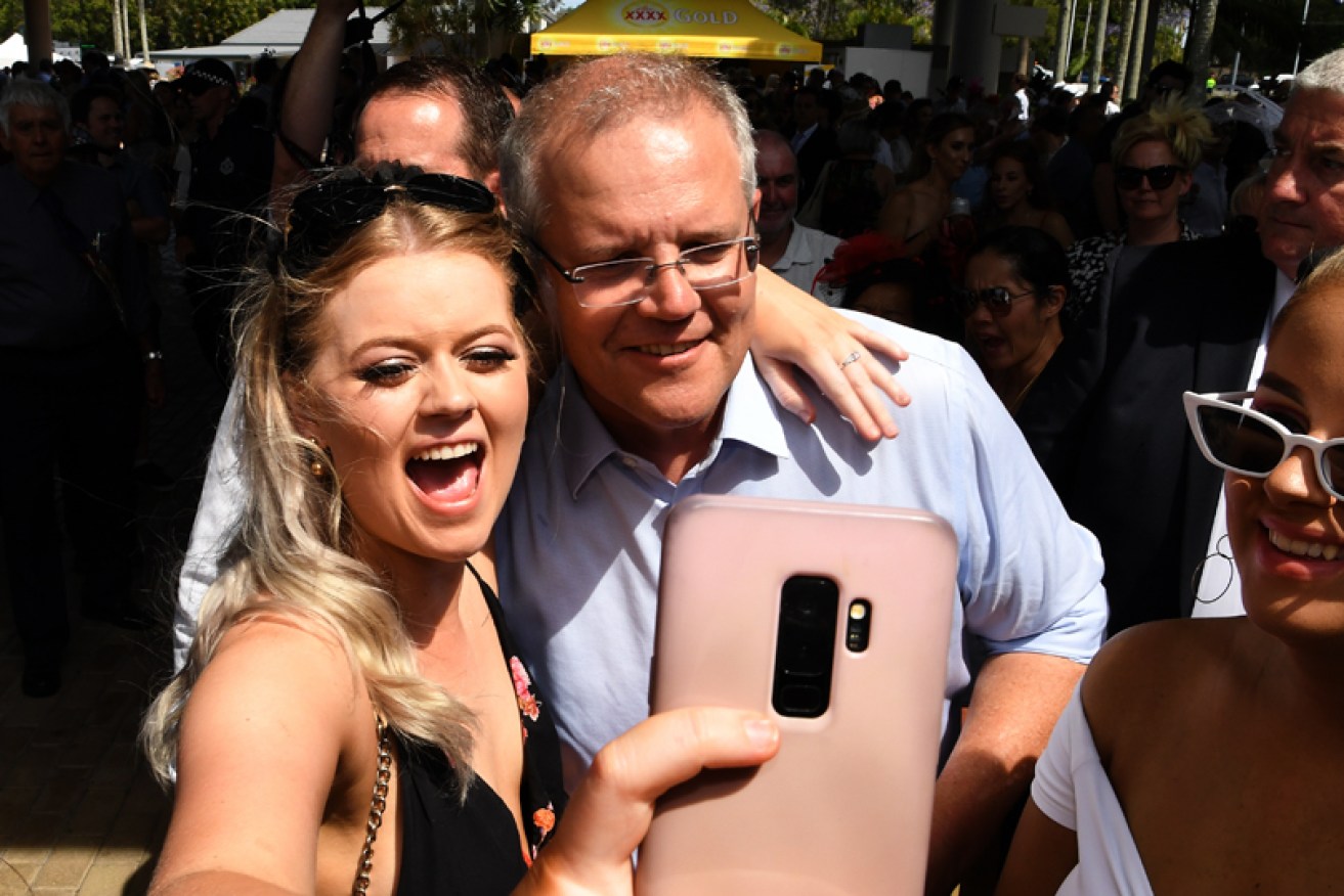 Scott Morrison takes a selfie with racegoers at Corbould Park on the Sunshine Coast on November 6.
