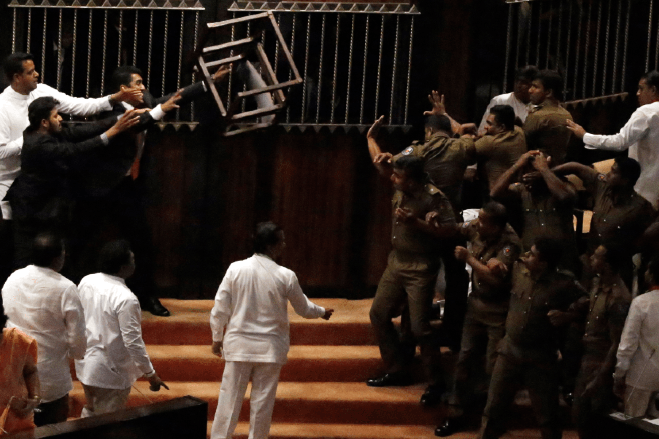 A chair goes flying across the chamber as police try to keep Sri Lanka's warring politicians apart.