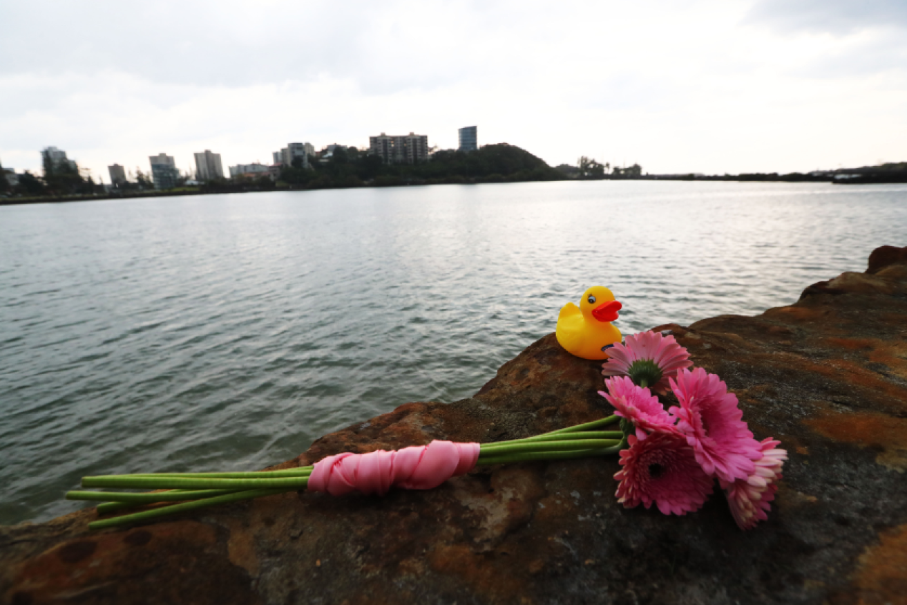 A rubber duck and a simple bouquet bound in pink ribbon mark the spot where the infant's life ended almost before it could begin. 