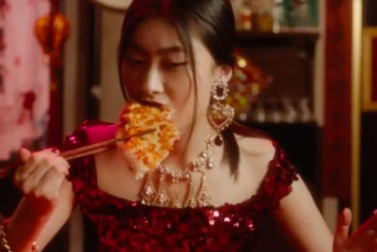 An ad showing a Chinese woman struggling to eat pizza with chopsticks has unleashed a firestorm on the company.
