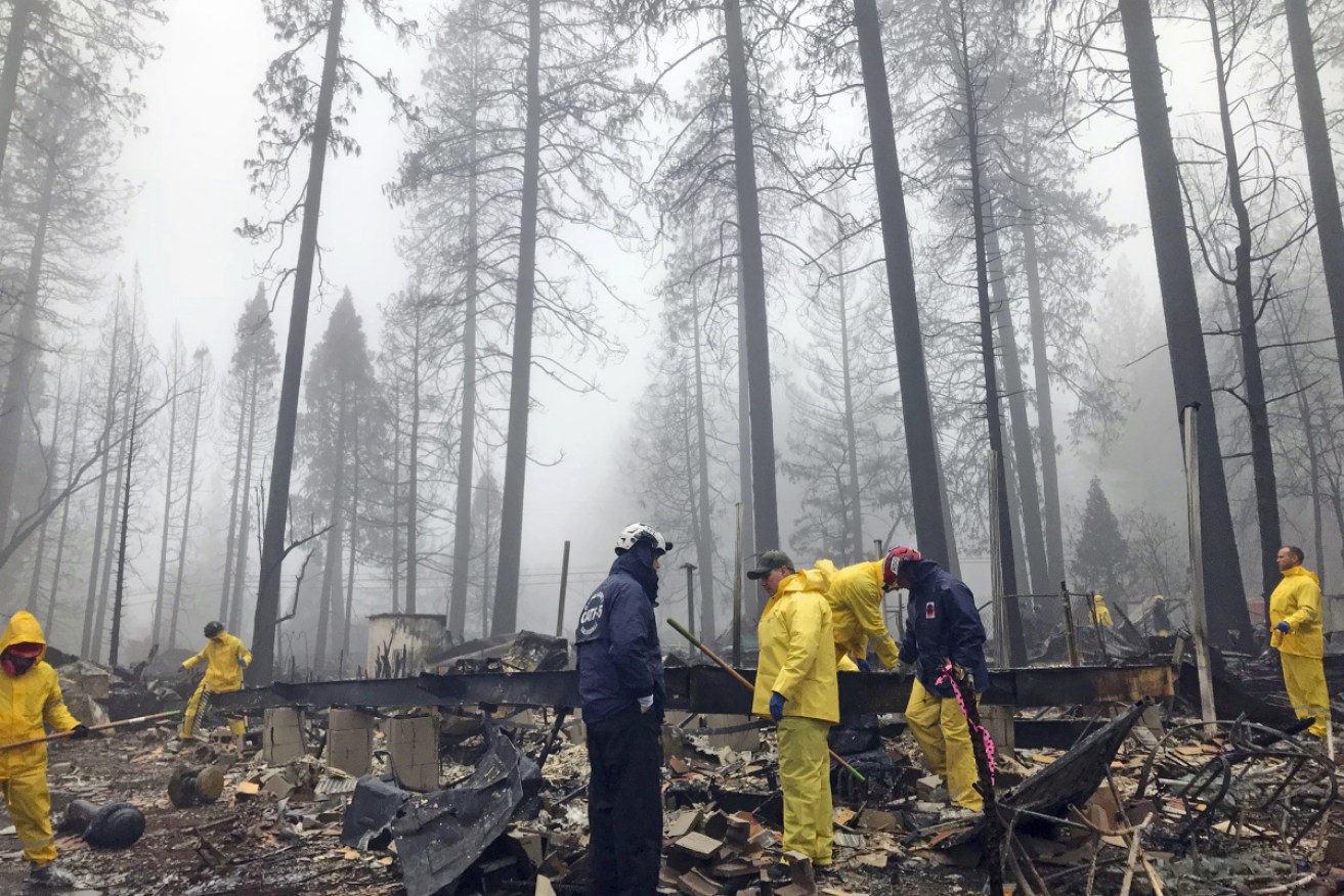 After a rain delay,  volunteers resume their search for human remains at a mobile home park in Paradise, California on November 23. 