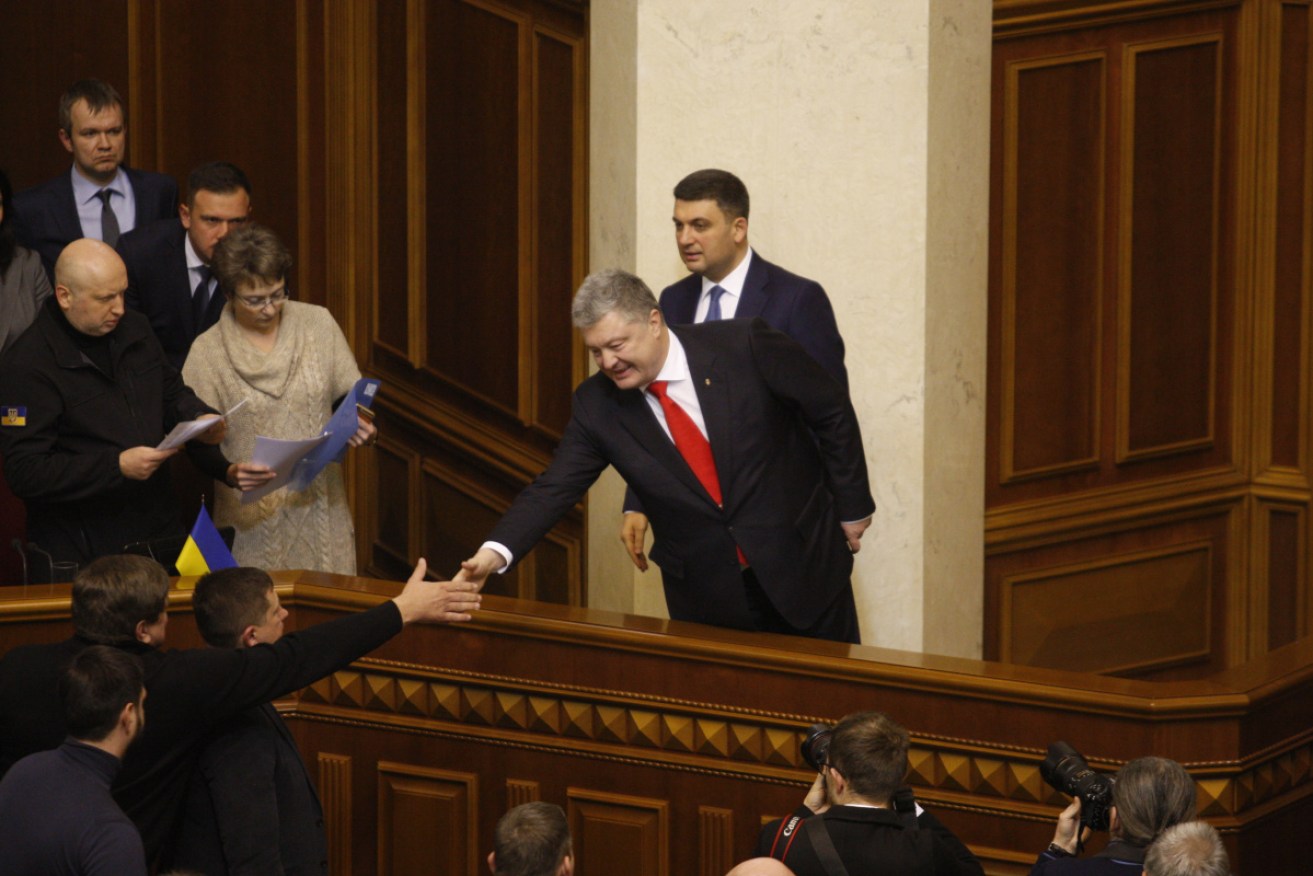 Ukrainian President Petro Poroshenko shakes hand with lawmakers after the Ukrainian Parliament voted for accepting martial law. 