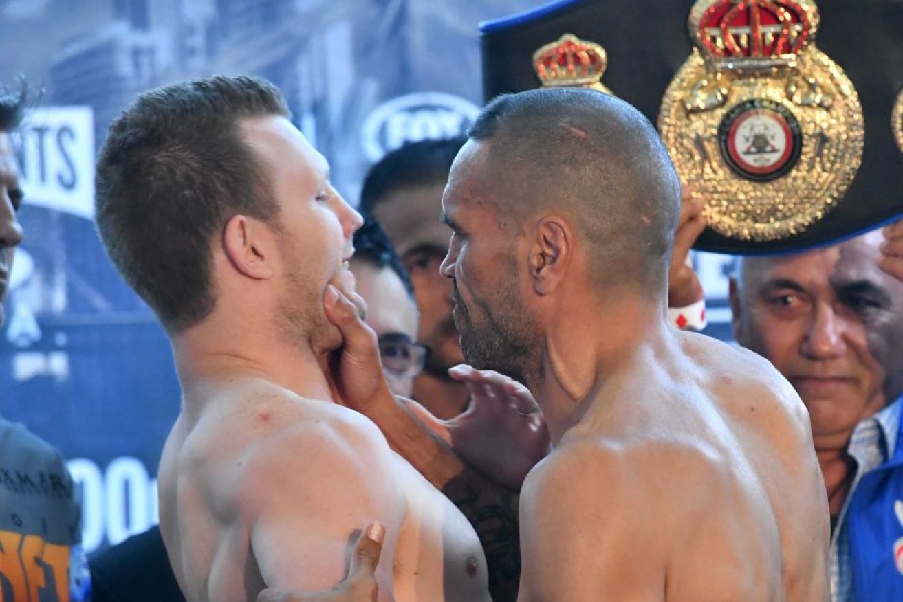 Anthony Mundine grabs Jeff Horn by the jaw at the weigh-in before Friday's bout.