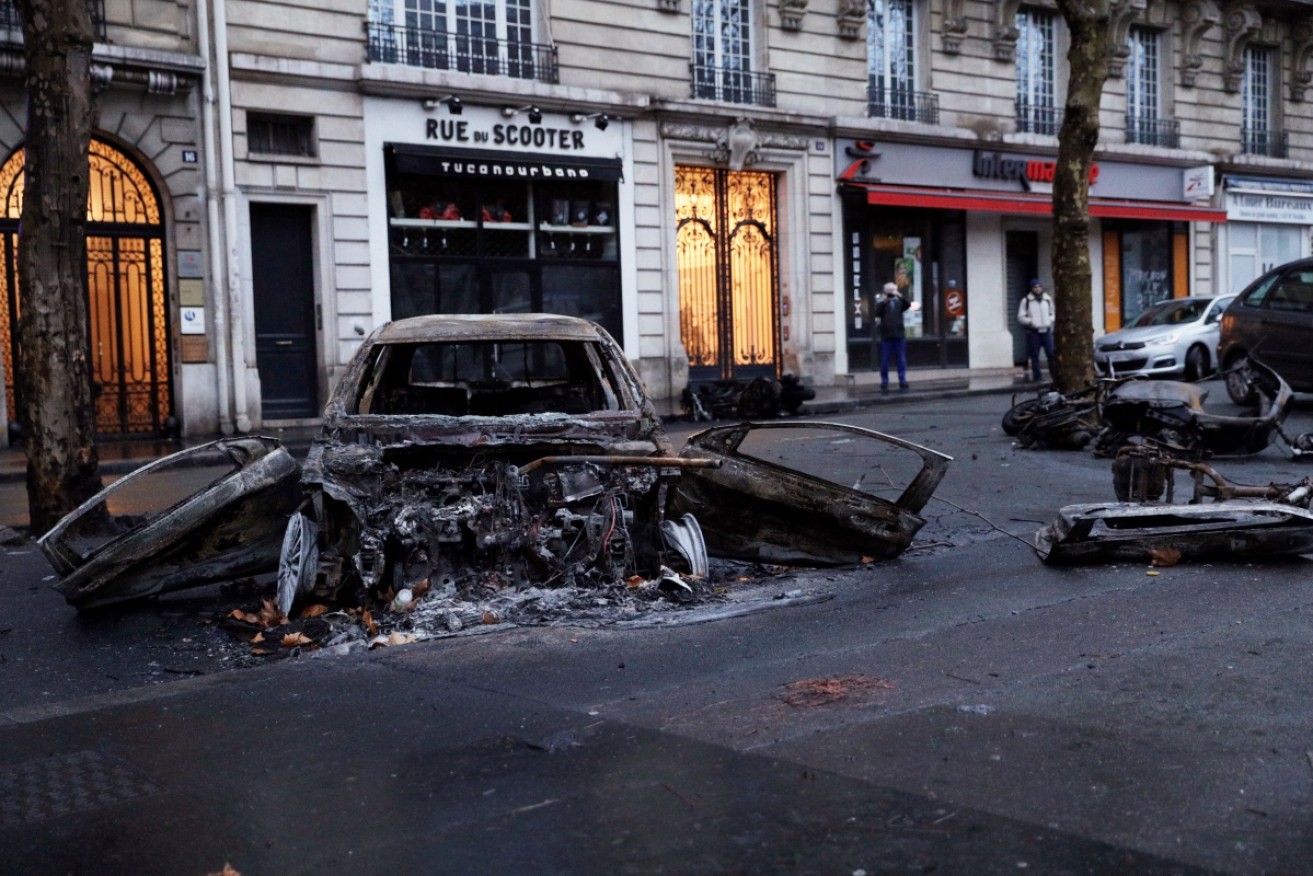 Anti-government protesters torched dozens of cars and set fire to storefronts during daylong clashes with riot police across central Paris.