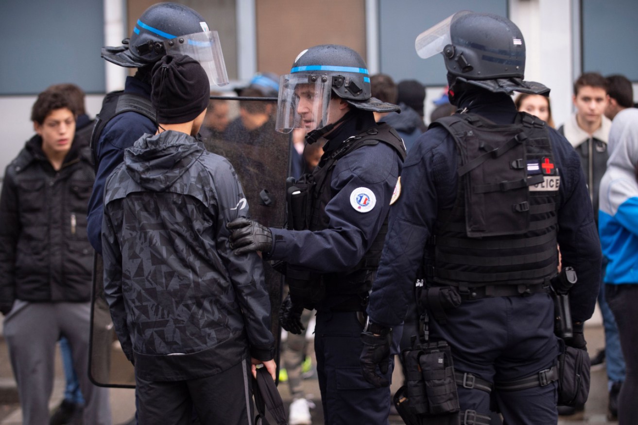A Riot police member speaks with a student during a demonstration of high school students protesting against French government Education reforms in Saint-Priest, France on December 6, 2018.