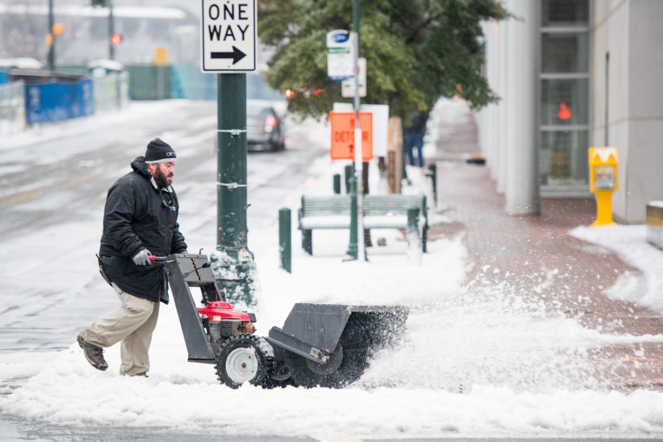 A snow sweeper clears a path in Charlotte, North Carolina after a storm in which 250,000 are still without power.  