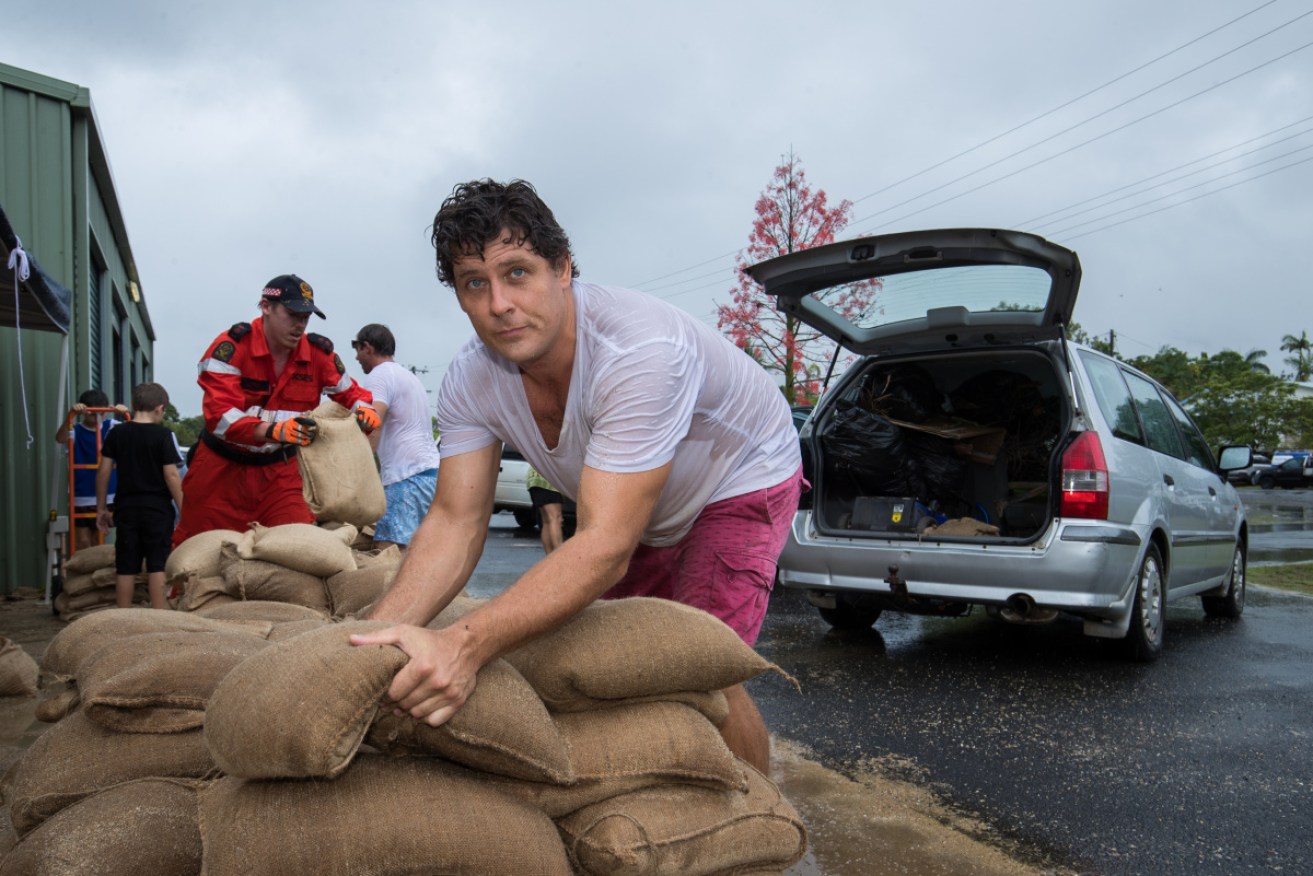 Steve Irving loads sandbags in Cairns earlier this month when Cyclone Owen dumped heavy rain in the region.