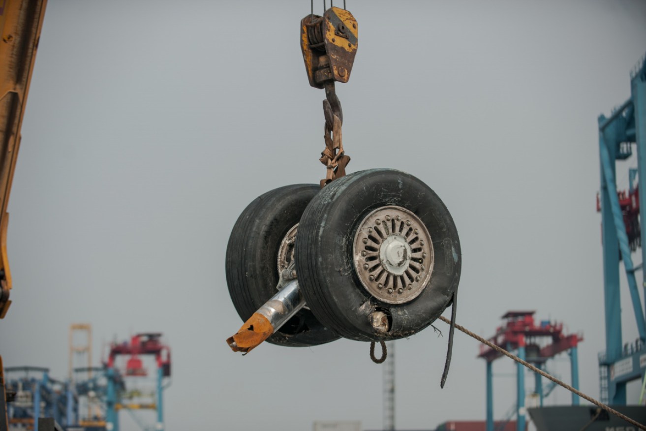 A plane wheel is pulled from Tanjung Priok Port in Jakarta by the crash of Lion Air JT 610 in November. 