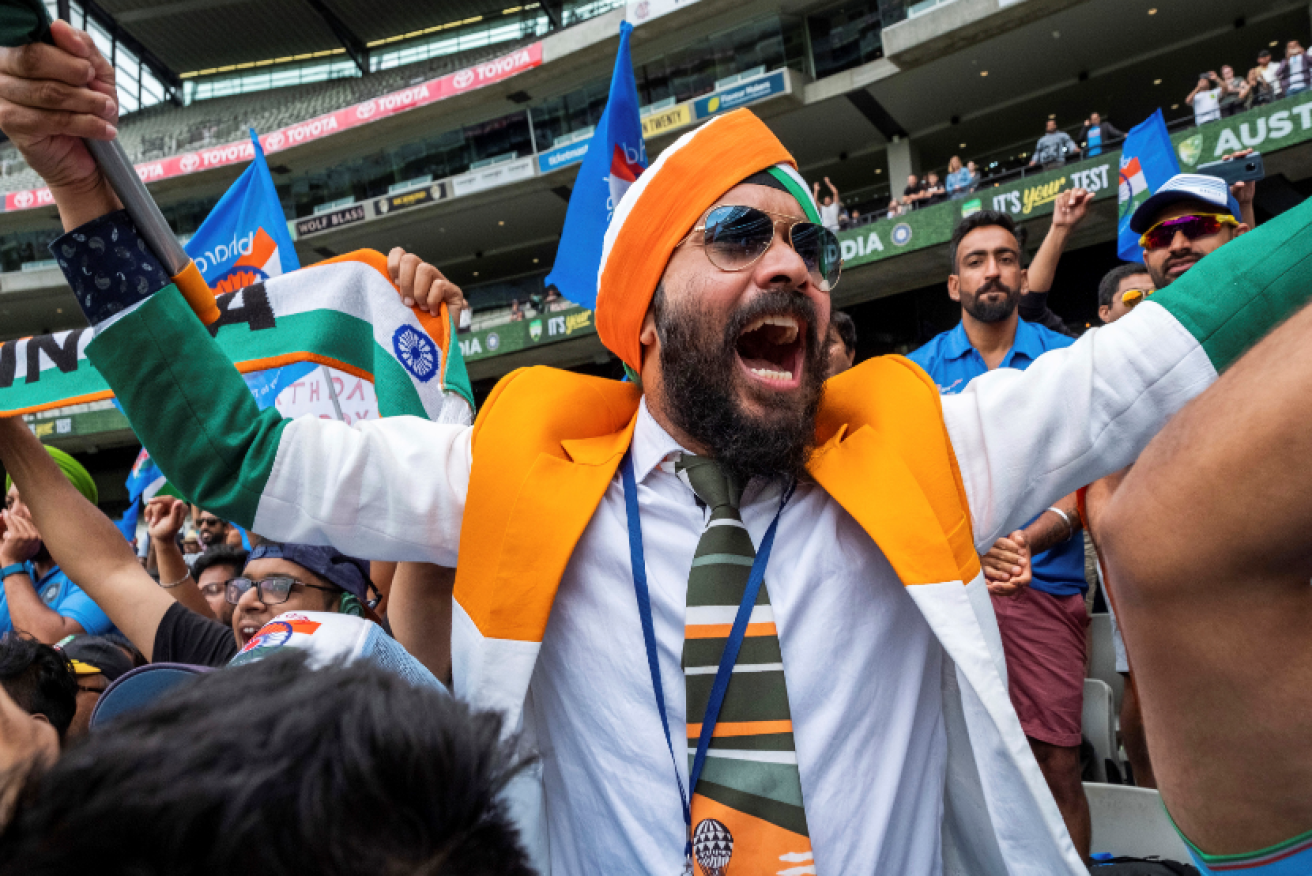 A wave of elation lifts this India supporter from his MCG seat as the final Australian wicket falls.