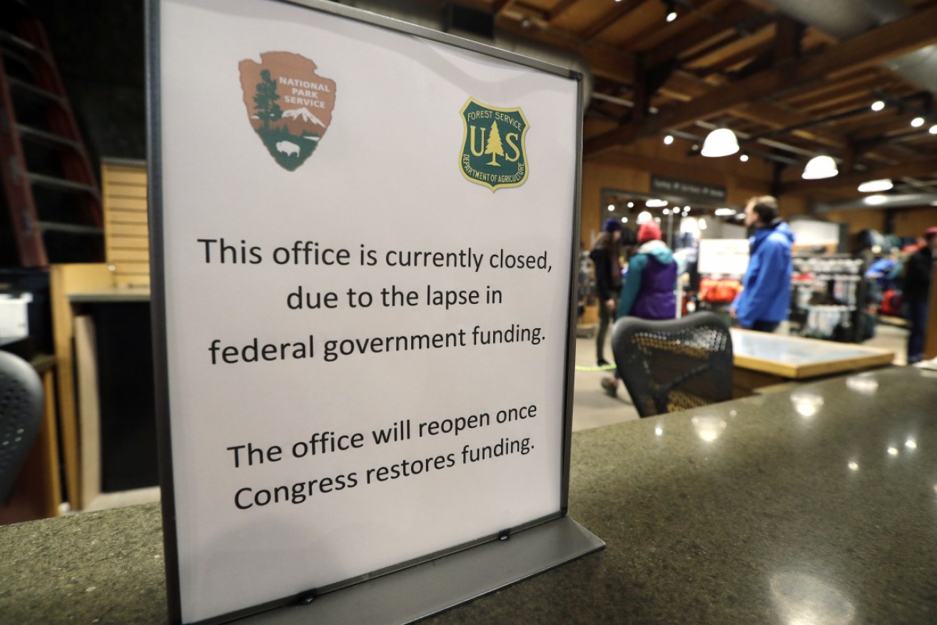 Campers walk past an unstaffed ranger station kiosk, closed as part of the US federal government shutdown, in Seattle.