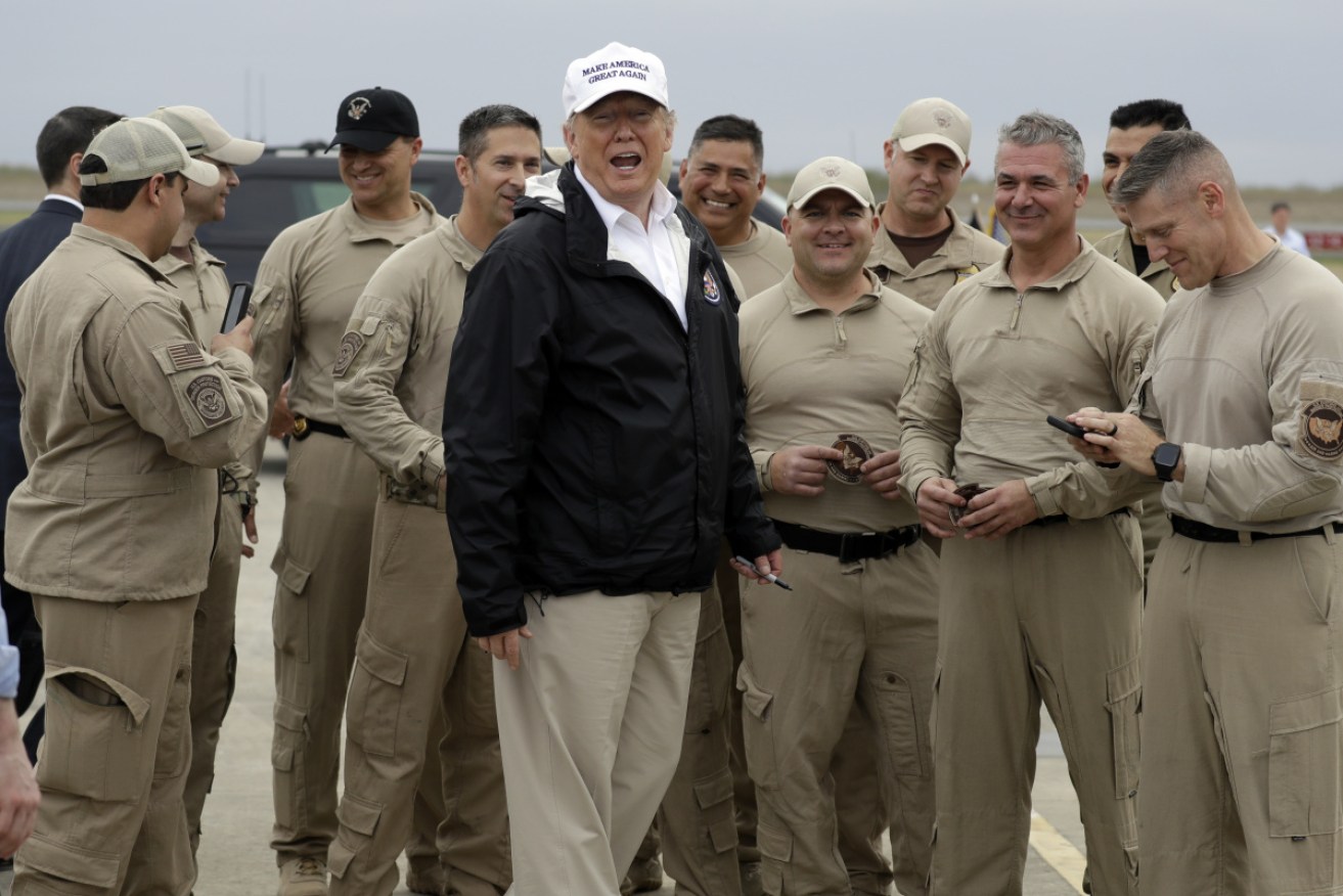President Donald Trump speaks with US Customs and Border Protection officers as he prepares to leave after a visit to the southern border.