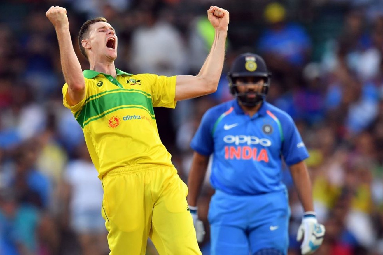 Jason Behrendorff (L) celebrates taking the wicket of India's MS Dhoni.