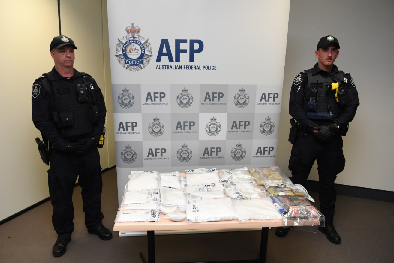 Police display the drugs and cash seized in the operation. 