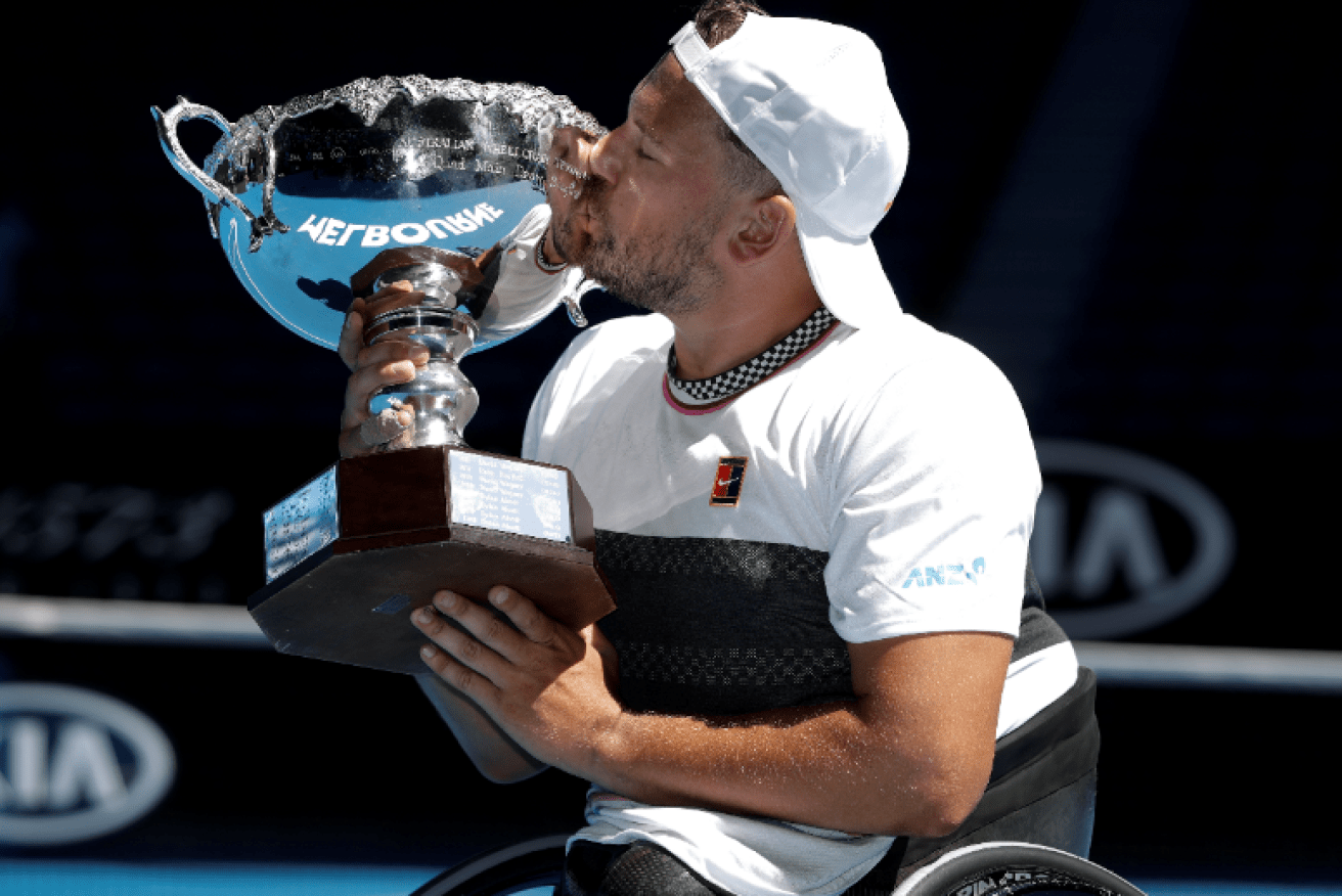 Dylan Alcott plants a big kiss on his fifth Australian Open quad-tennis singles crown.