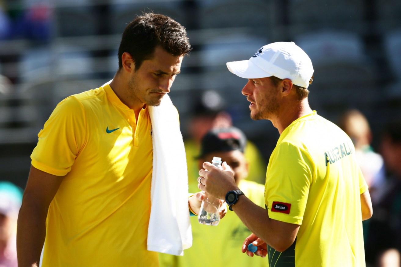 Before the fall: Bernard Tomic receives advice from Lleyton Hewitt in September 2016. 