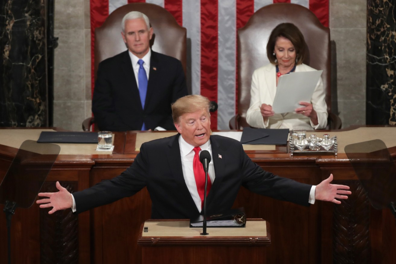 Donald Trump addresses Congress, flanked by Mike Pence and Nancy Pelosi. 