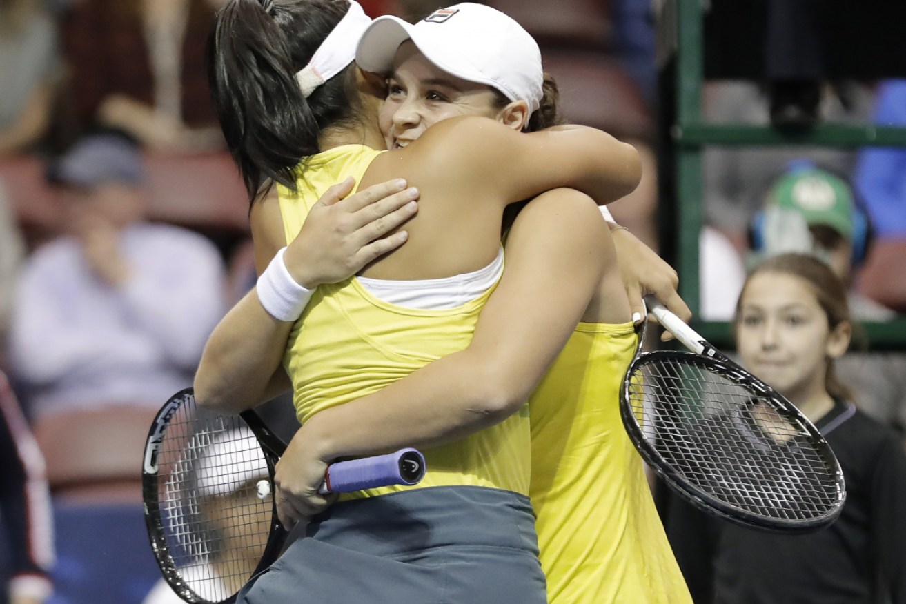 Ashleigh Barty and Priscilla Hon hug after defeating the United States in their first-round Fed cup tennis match.