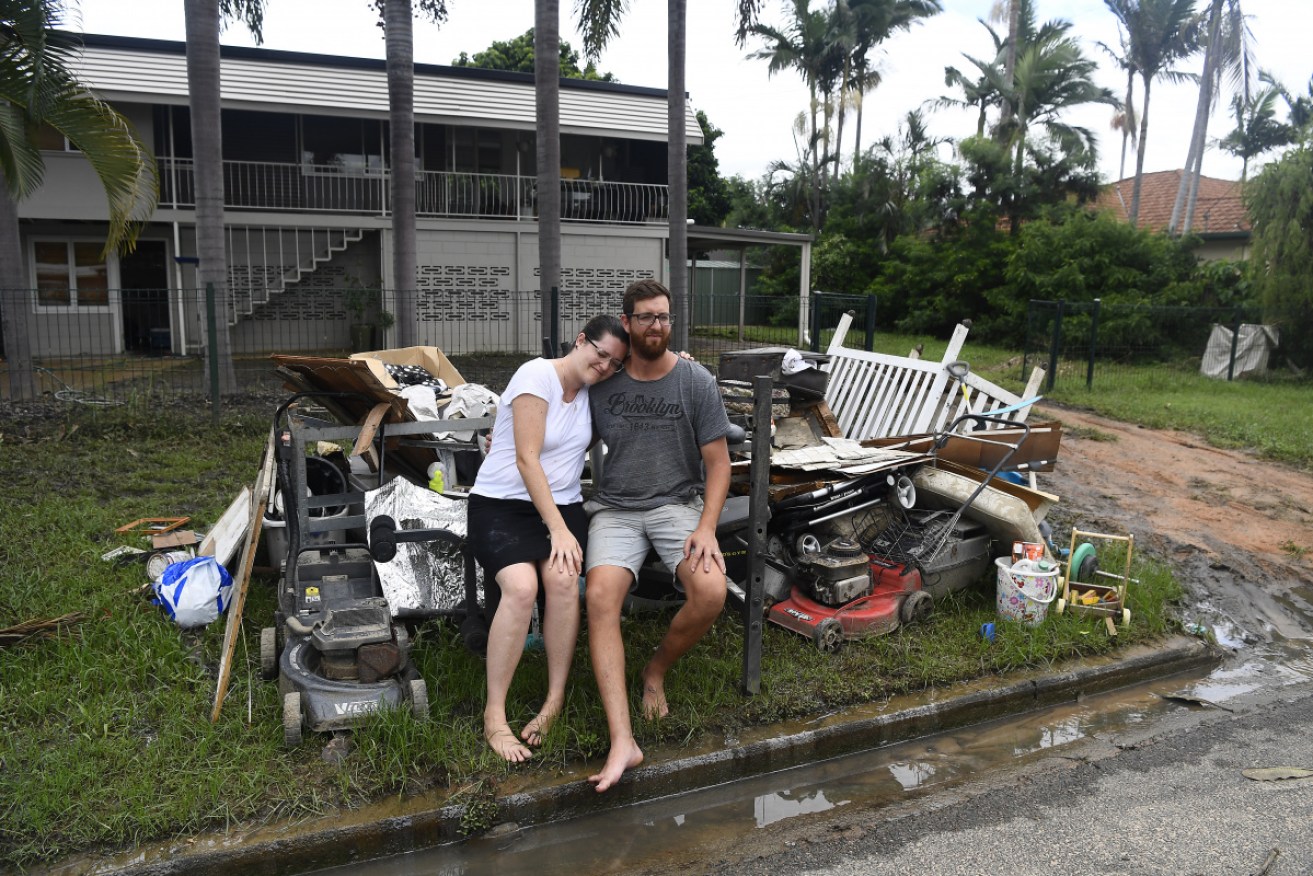 Taneth and Adam Vale pose outside their flood-damaged home on February 8.  