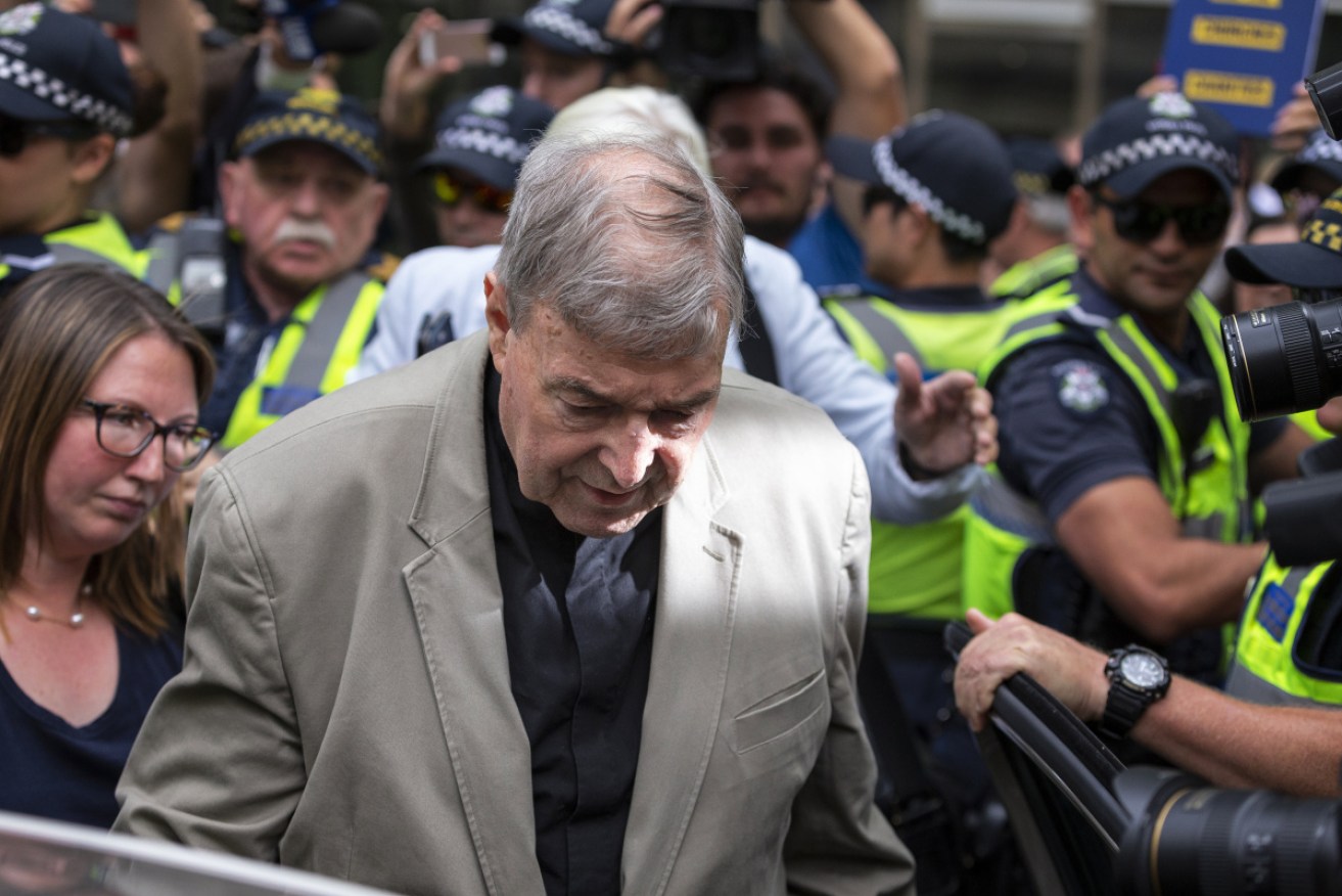 Cardinal Pell leaves the court on Tuesday after a decision was made to lift a gag order suppressing the guilty finding against him.
