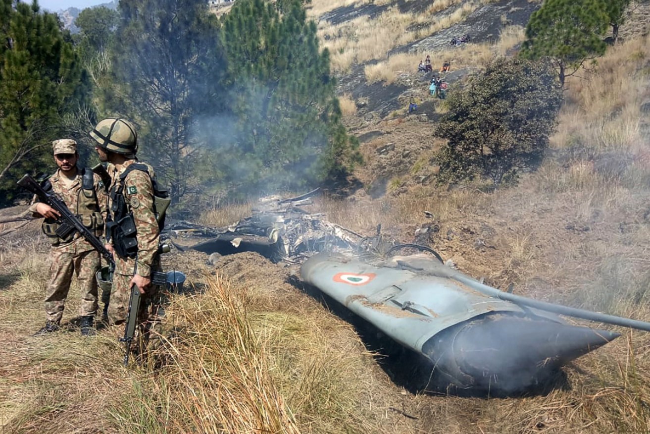 Soldiers stand next to the wreckage of an Indian fighter jet shot down in Pakistan-controlled Kashmir near the Line of Control. 