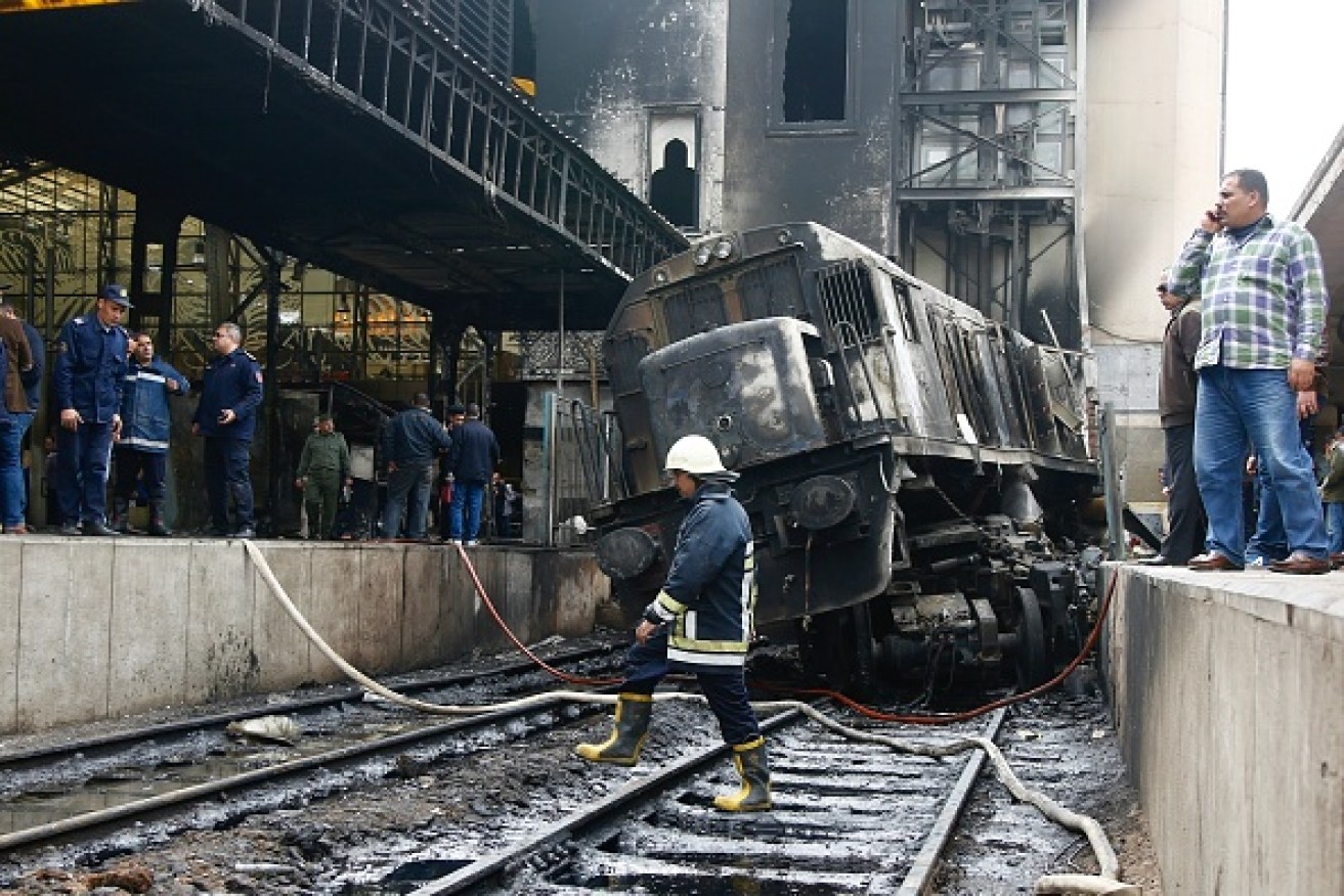 Fire fighters and onlookers gathered at the scene of a fiery train crash at Cairo's main railway station.