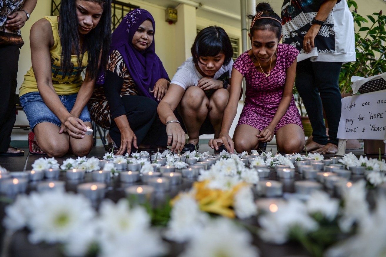 School teachers put candles on the floor to pay tribute to passengers of missing Malaysia Airlines flight MH370 in Petaling Jaya, Malyasia