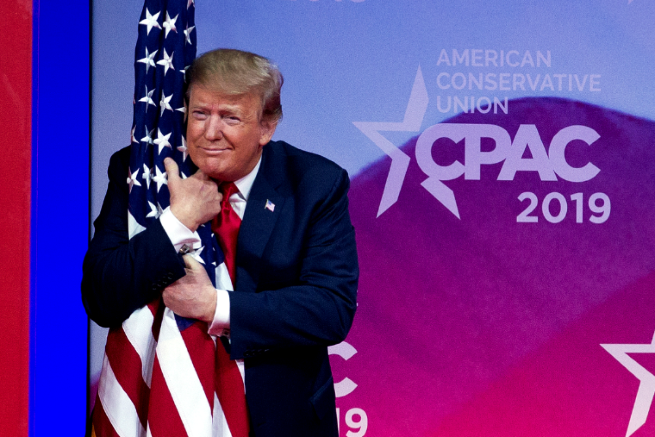Donald Trump hugs the Stars and Stripes as the crowd goes wild during his two-hour attack on his enemies.
