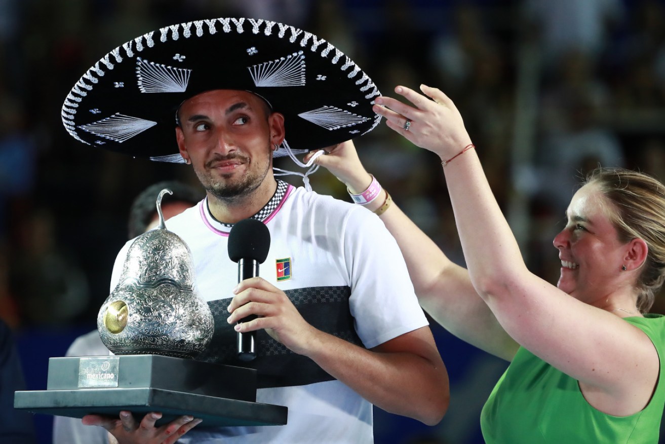 If the cap fits ... an unsure Nick Kyrgios tries on his sombrero after winning the Mexican Open on Sunday. 