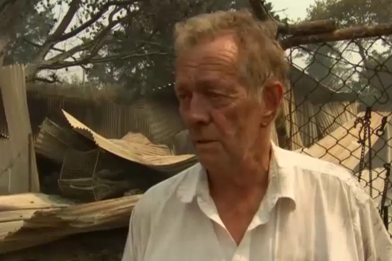 Tonimbuk survivor Rex Newton surveys the charred wreckage of his obliterated home.
