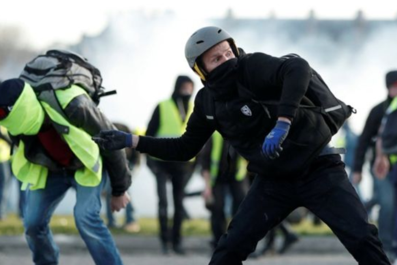 A Paris protester lobs a rock at police during the protest movement's initial eruption in 2018.