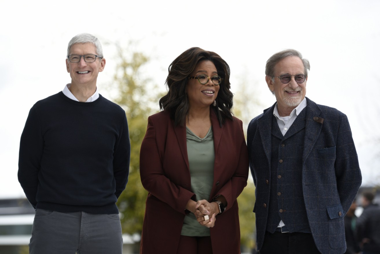 Oprah announces her new partnership with Apple alongside company CEO Tim Cook (L) and director Steven Spielberg (R)
