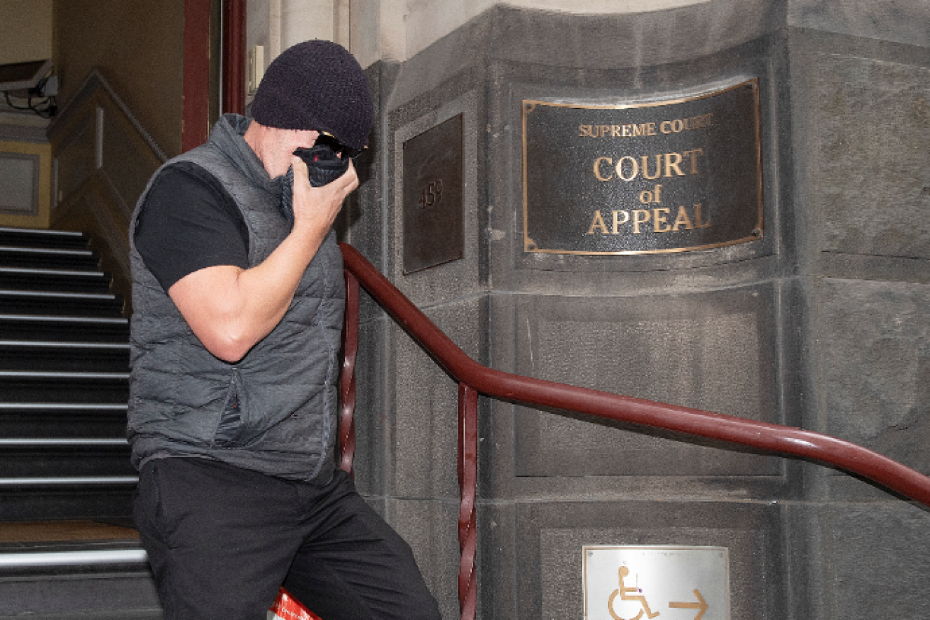 Unsuccessful litigant David Hingst hides his face as he exits the court after losing his appeal bid.