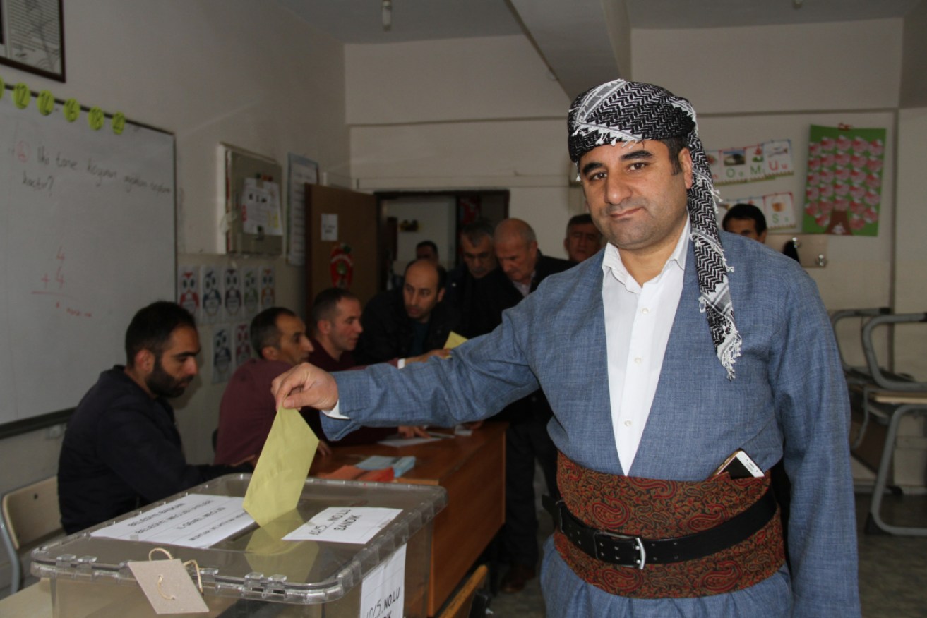 A voter casts his ballot at a polling station during local elections in Hakkari, Turkey. 