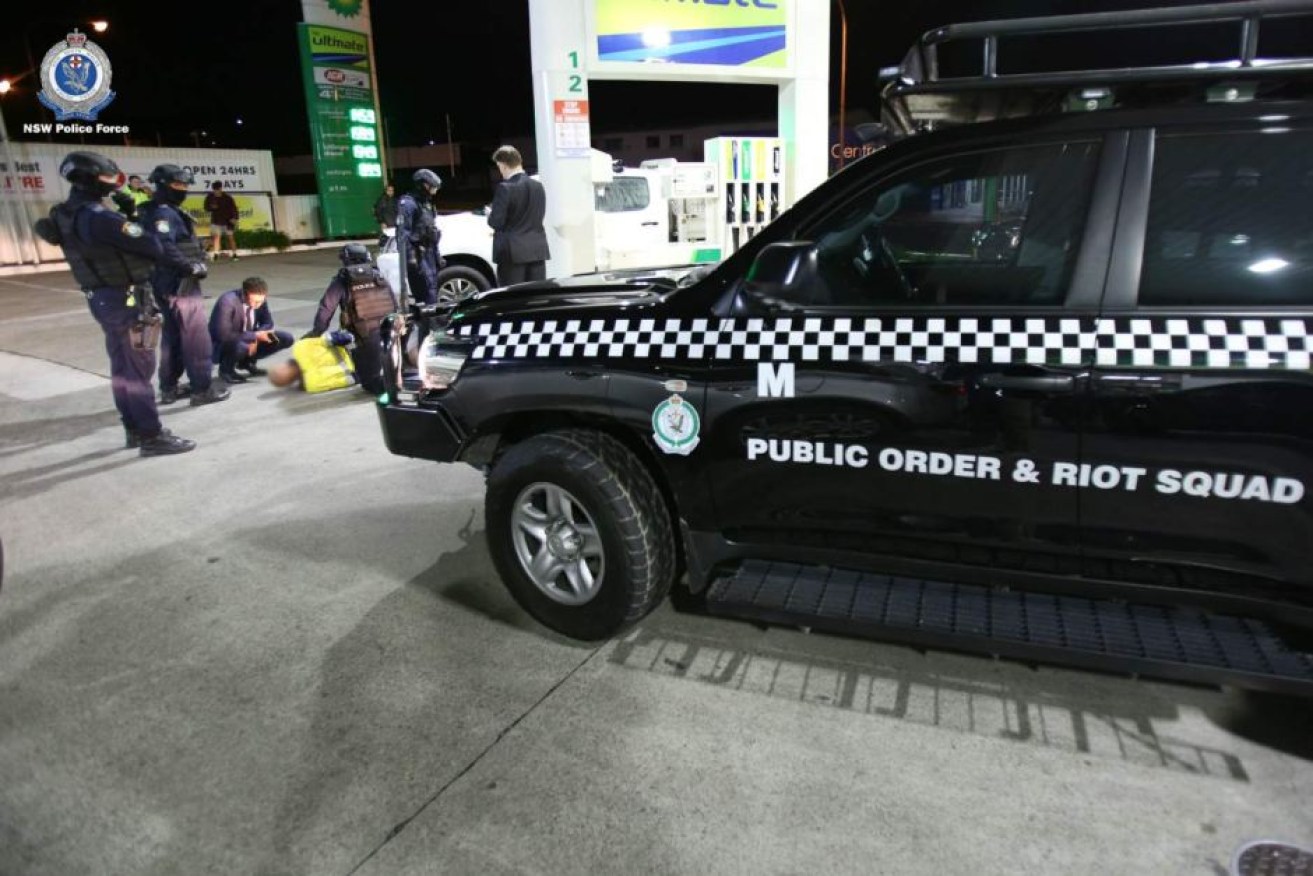 Police arrest a man at a petrol station in the Illawarra over an alleged car bombing.

