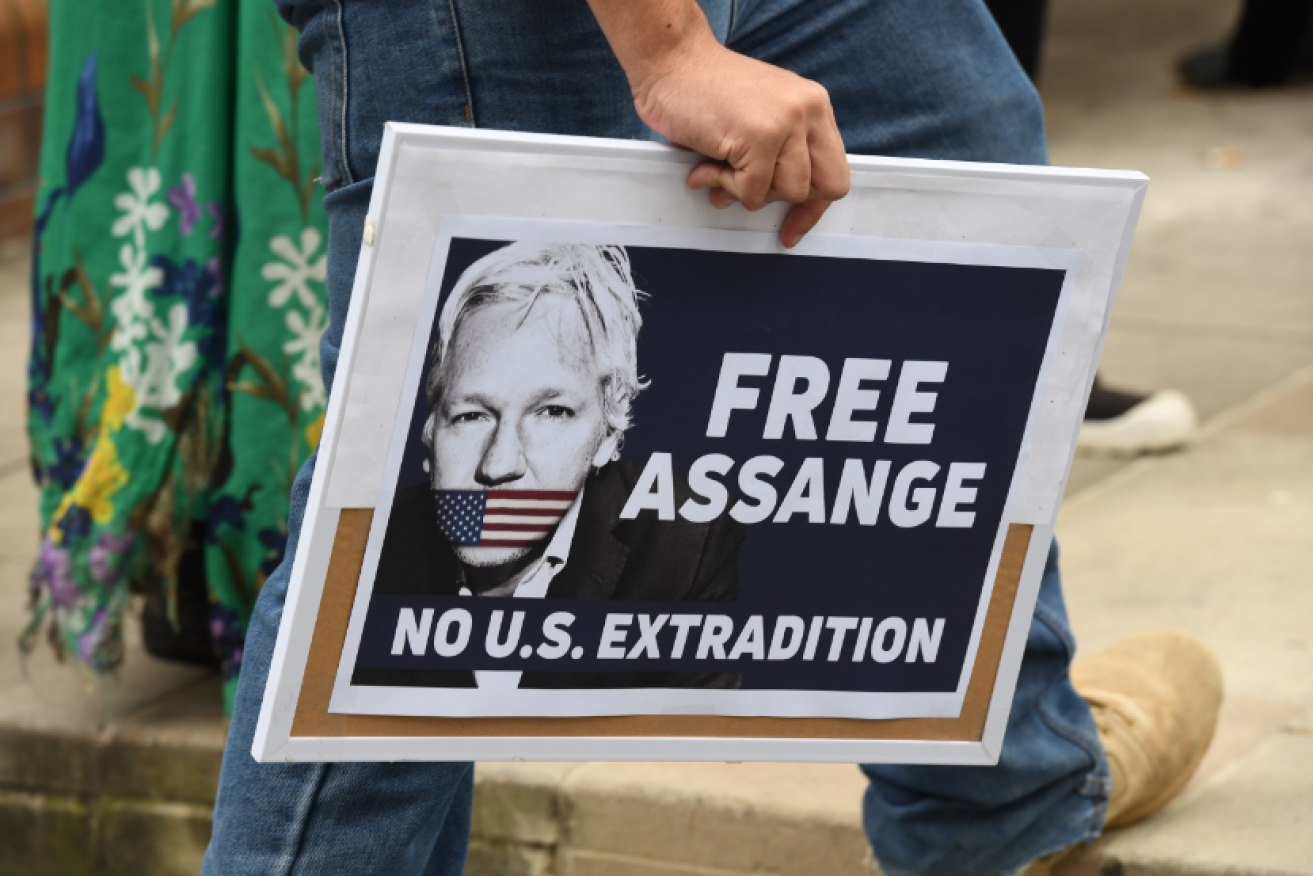A protester and his sign head to a pro-Assange rally in Sydney.