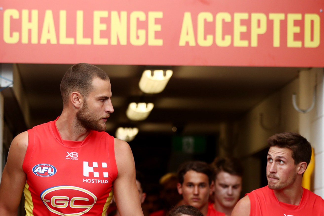 Jarrod Witts and David Swallow lead out the Suns at Metricon Stadium before its nailbiting win over Carlton on Sunday. 
