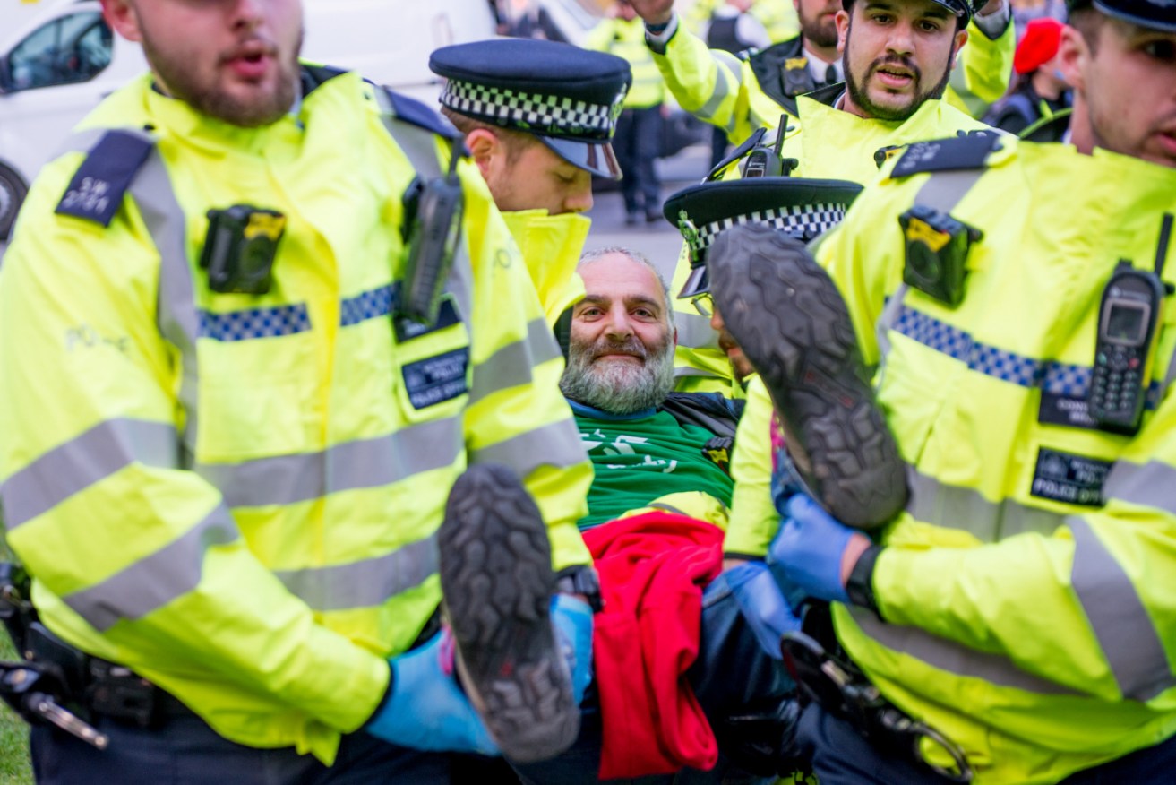 Police arrest an Extinction Rebellion protester. He is one of 300 arrested this week.