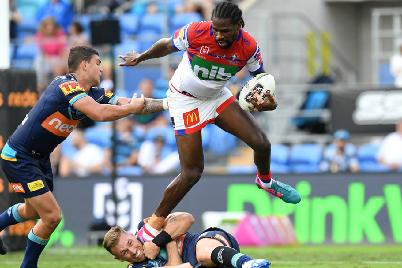 Newcastle's Edrick Lee attempts to break free the defence of Gold Coast Titans' Bryce Cartwright on Sunday. 