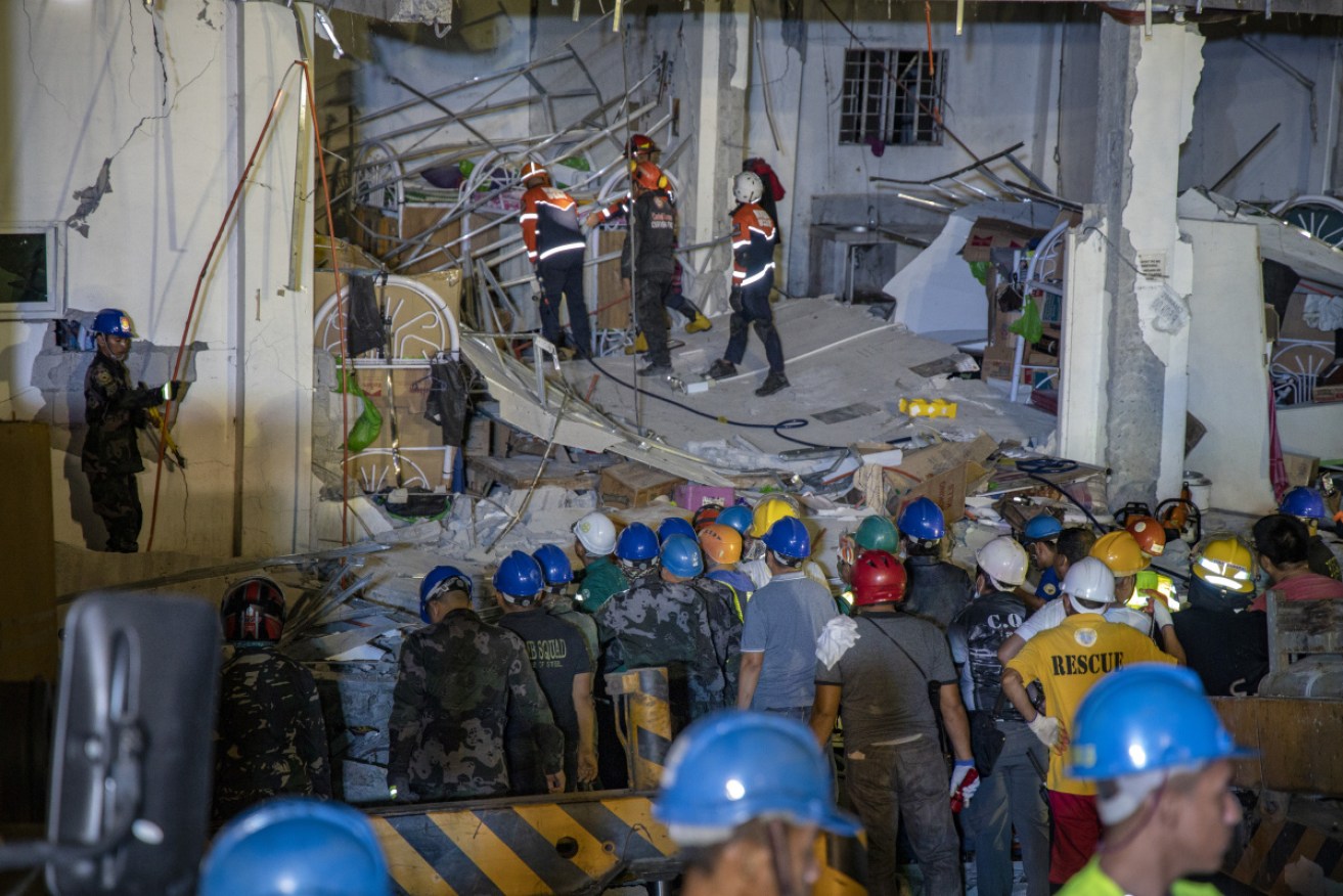 Rescuers search for survivors trapped in the debris of a four-storey commercial building at Porac, Philippines. 