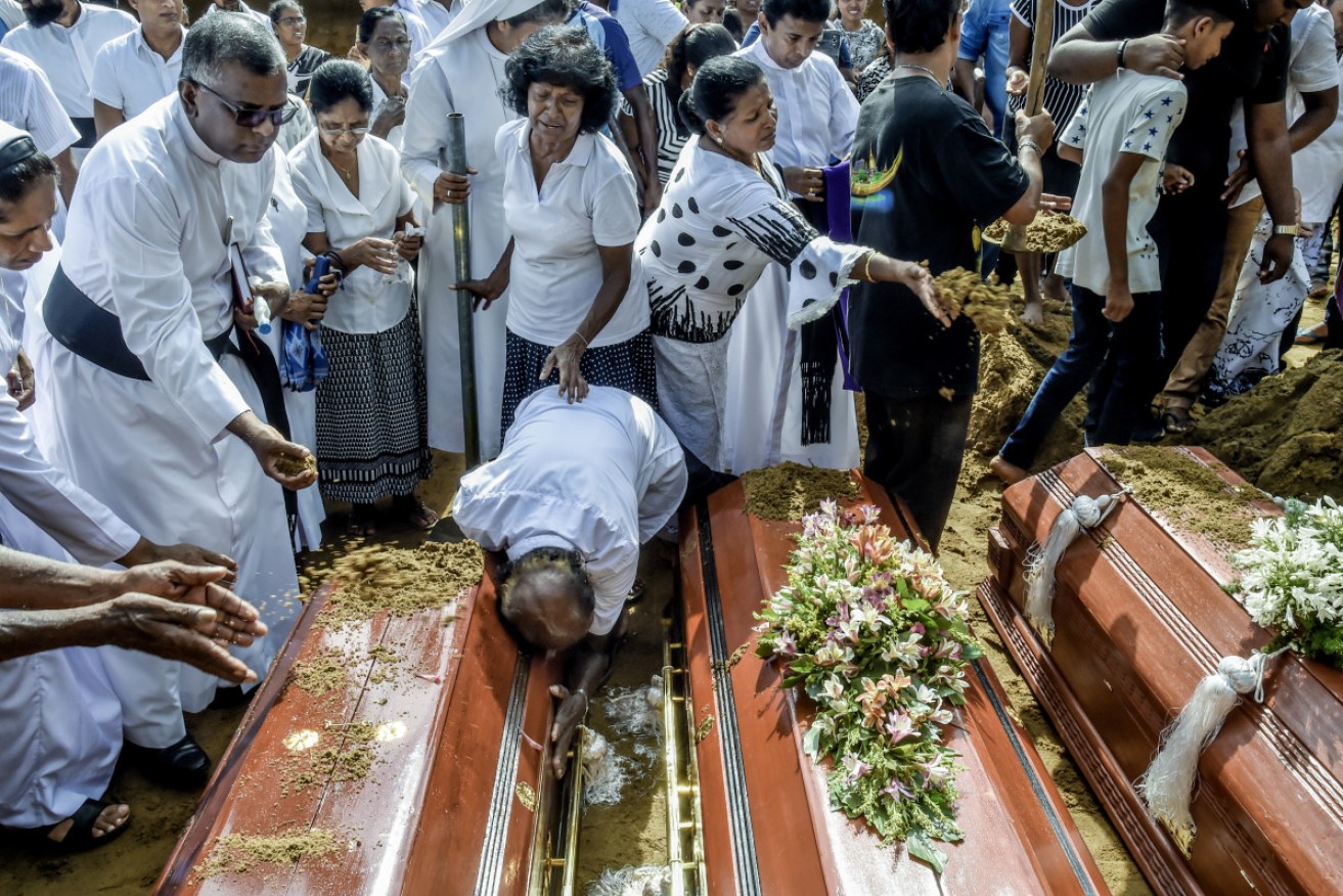 Relatives of the dead offer their prayers during funerals in Katuwapity village in Negombo, Sri Lanka.