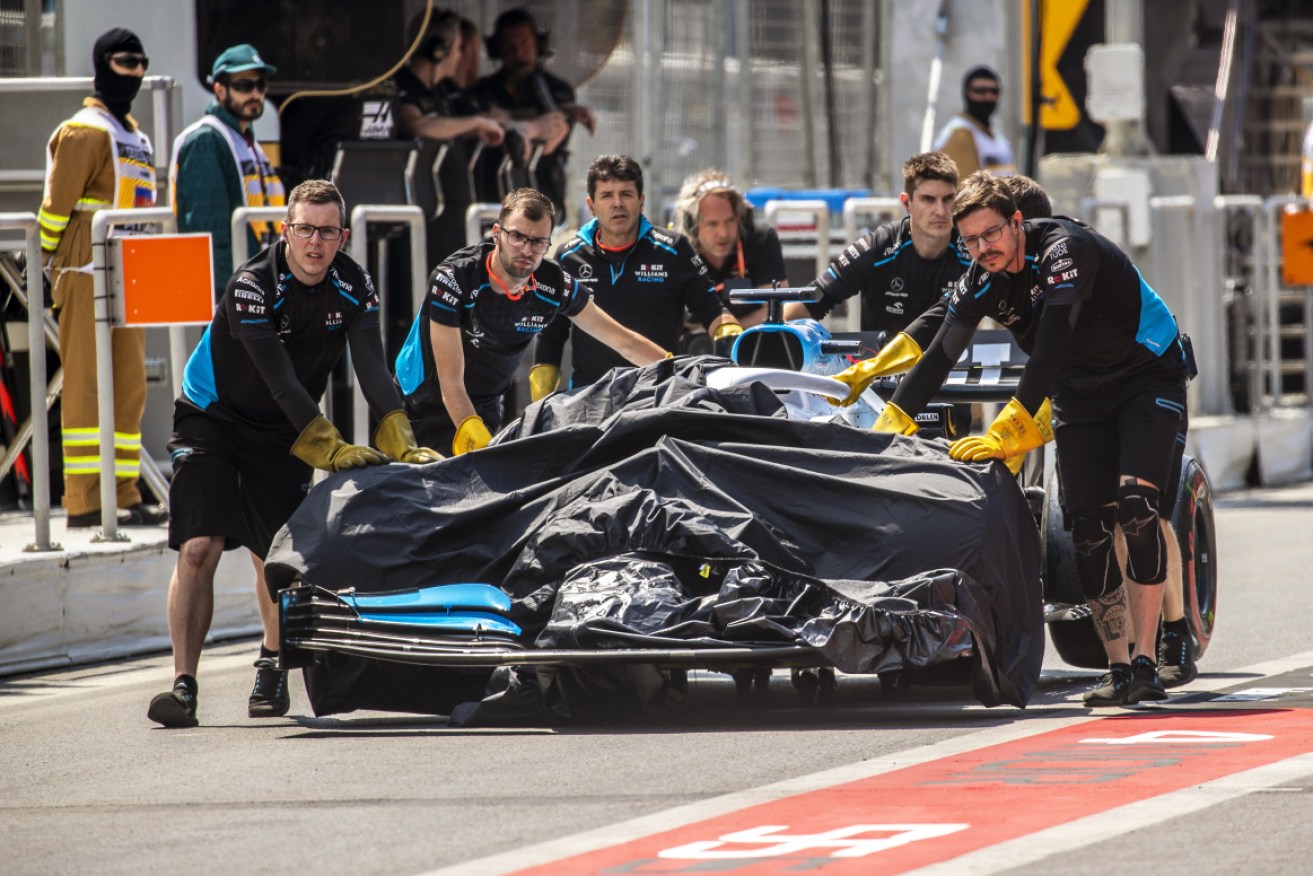 Mechanics push the car of British Formula One driver George Russell of Williams back to their team's garage after an accident during the first practice session at Baku, Azerbaijan.  
