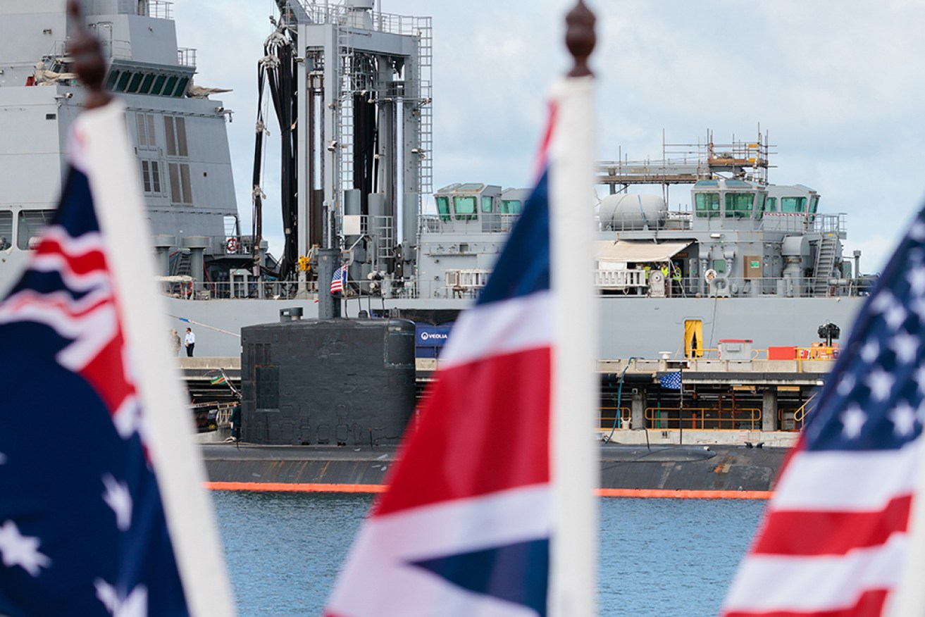 National flags of the Australia, Great Britain and the USA are seen in front of the USS Asheville, a Los Angeles-class nuclear powered fast attack submarine during a tour of HMAS Stirling in Perth, Thursday, March 16, 2023. AAP Image/Richard Wainwright) NO ARCHIVING