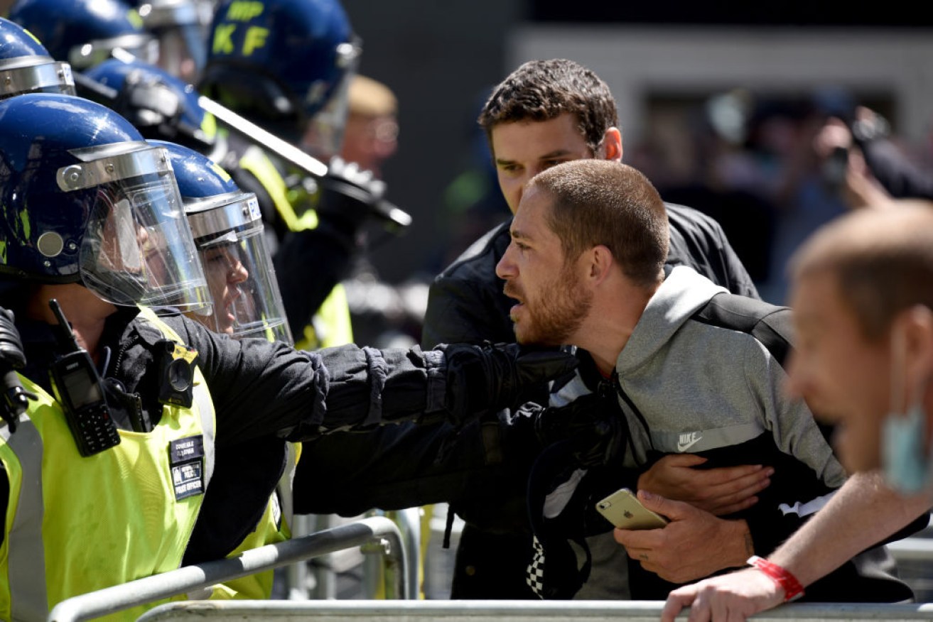An activist argues with a police officer on Parliament Street as counter-protests erupted in London.
