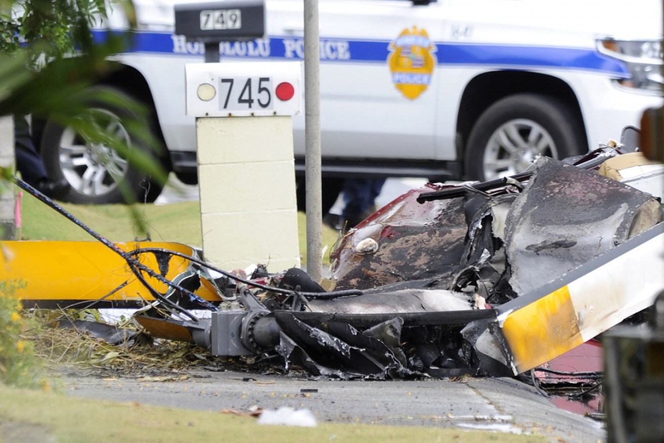 Wreckage from the helicopter crash that killed an Australian woman lies on a suburban Hawaiian street.