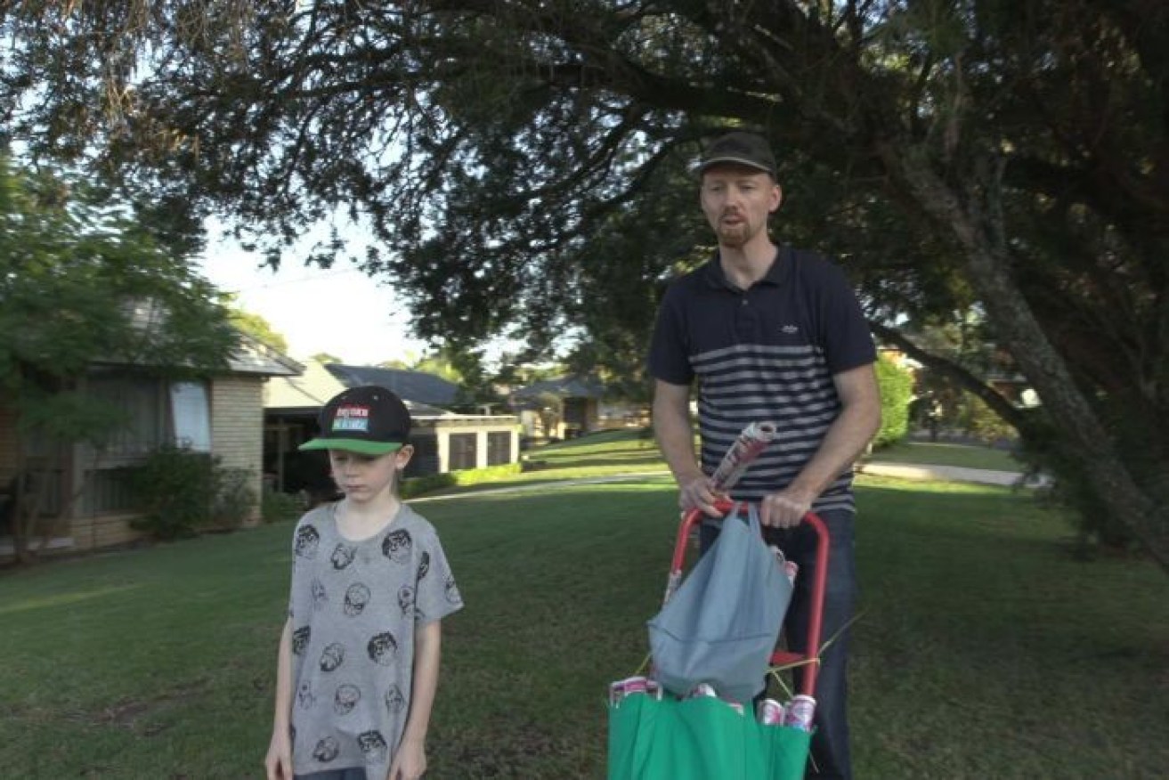 PHOTO: Julian Evans and his sons deliver newspapers to make some extra cash. (ABC News)