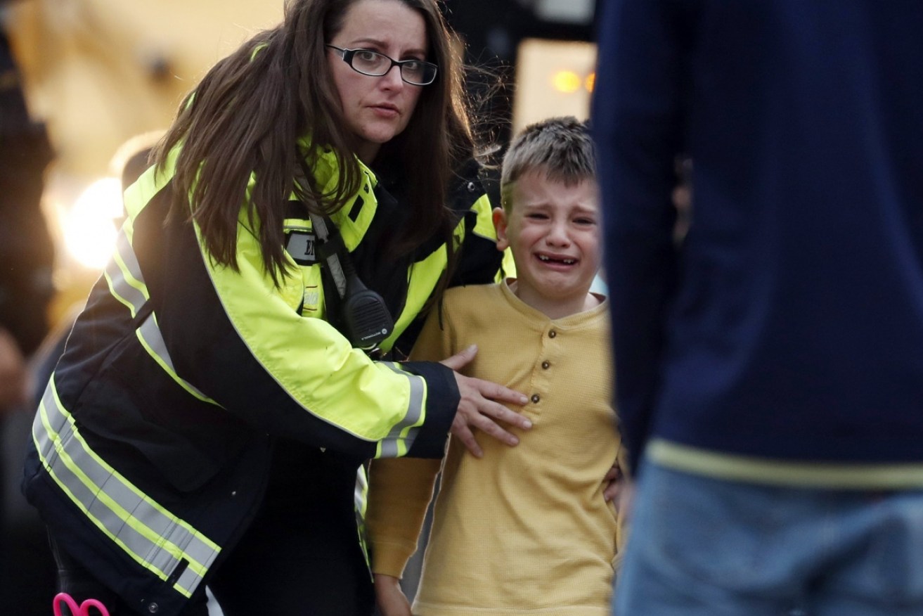 A young boy is comforted after escaping the Highland Ranch school shooting.