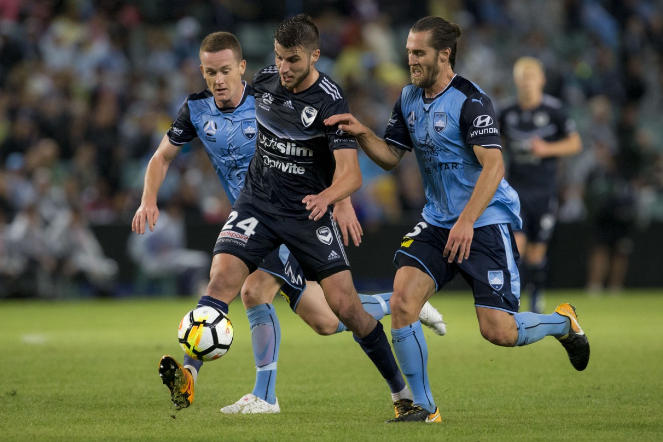 Victory midfielder Terry Antonis under pressure from Sydney FC's Brandon O'Neill  and Joshua Brillante in the 2018 semi-final.  